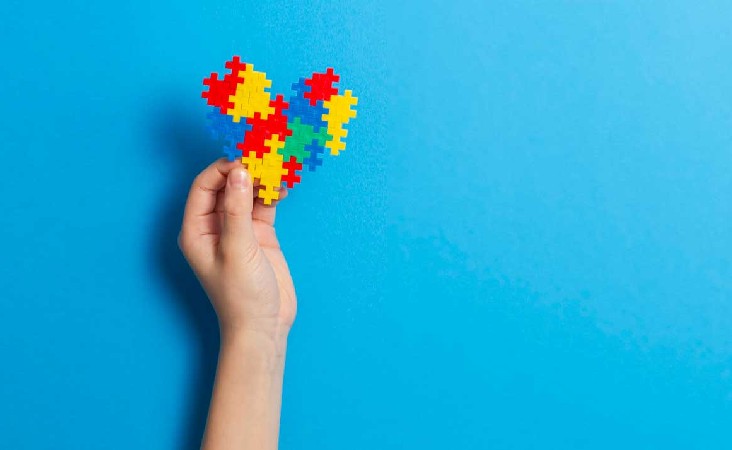 Child's hand holding up puzzle piece heart