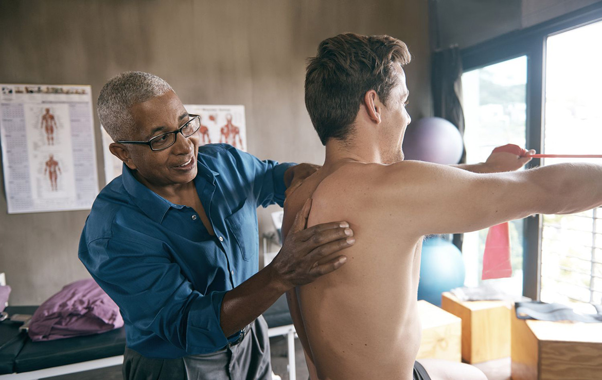 Chiropractor examining back of patient