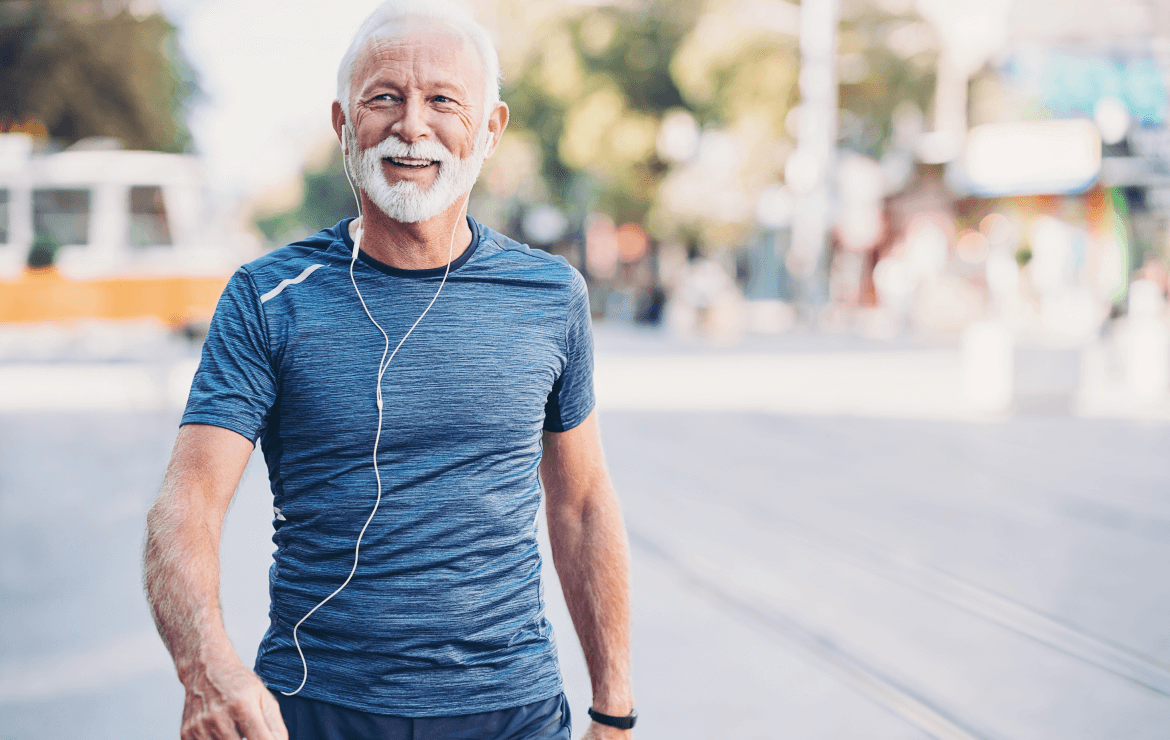 Older man wearing earphones while walking outside