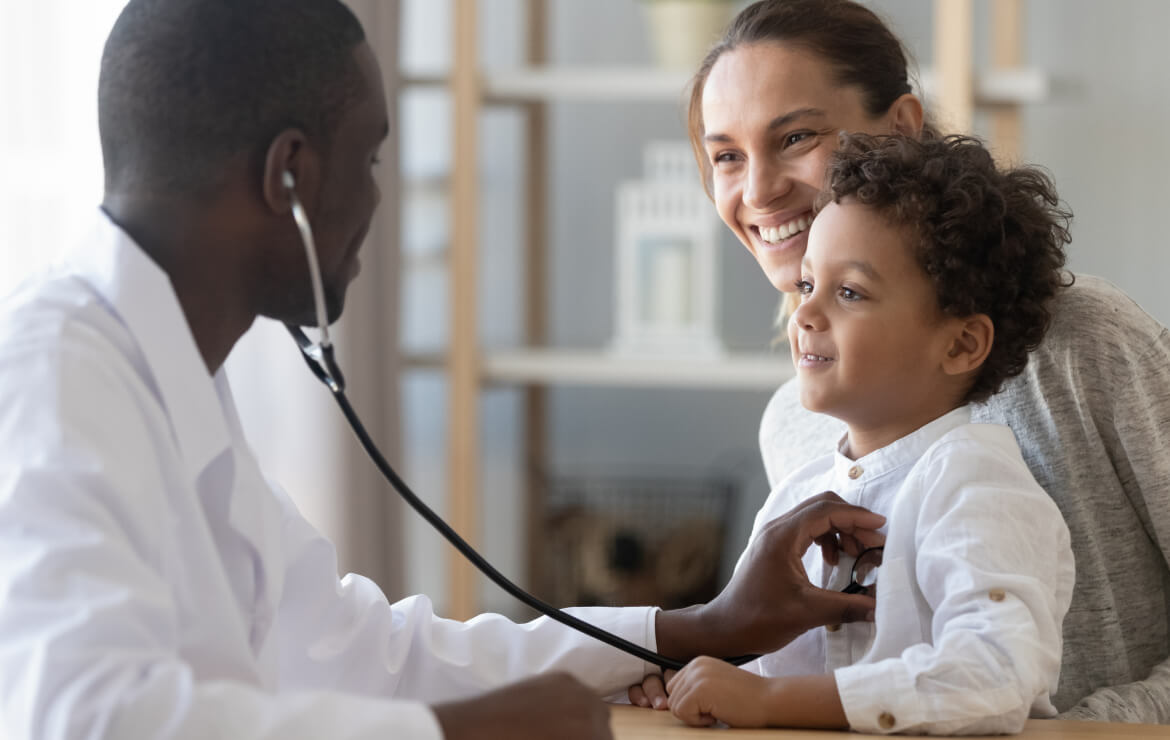 Pediatrician holding stethoscope on patient's chest