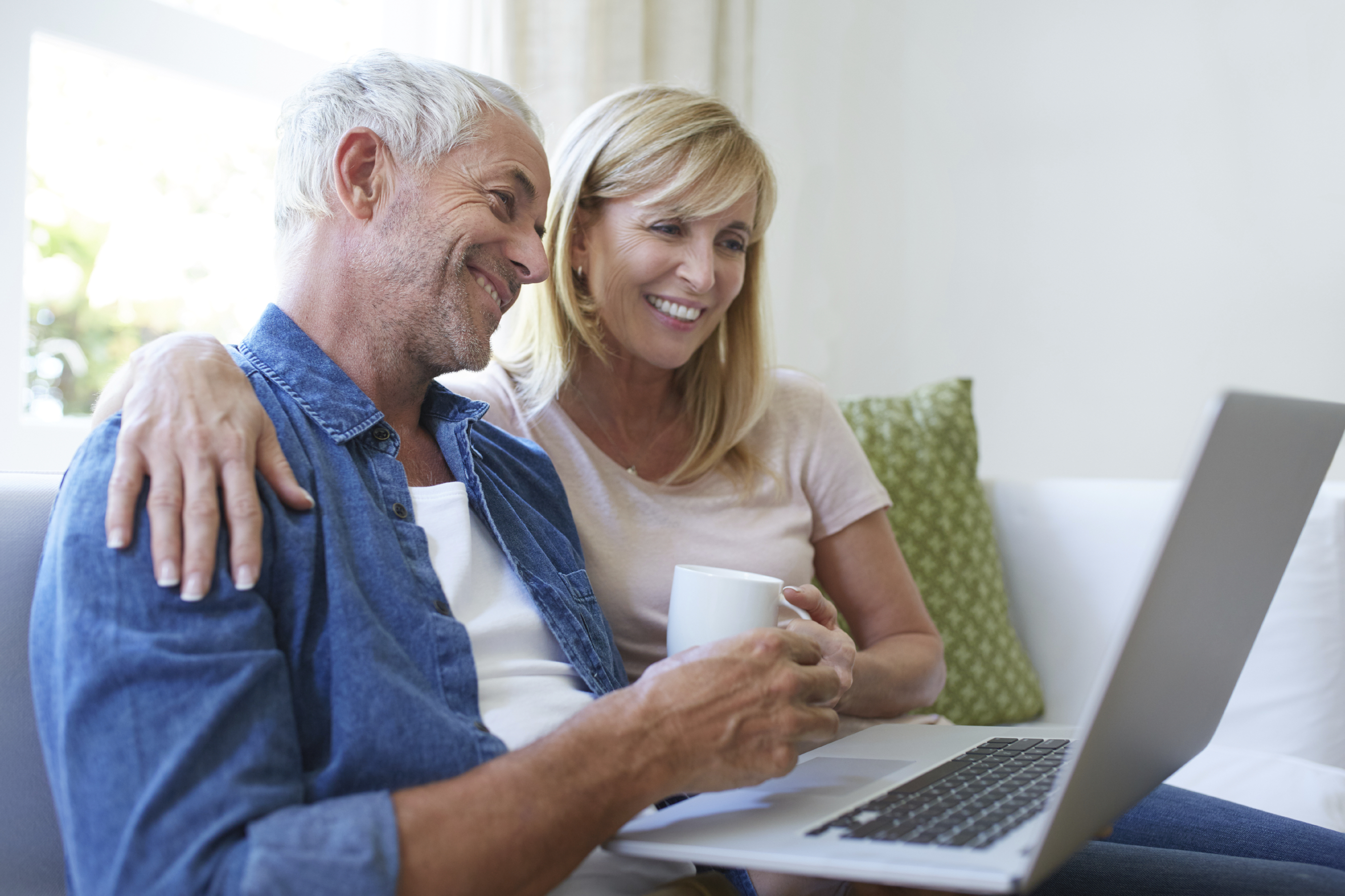 Older couple sitting together in front of laptop