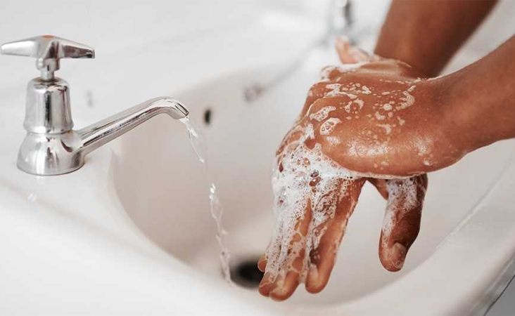 Washing hands with soap in sink